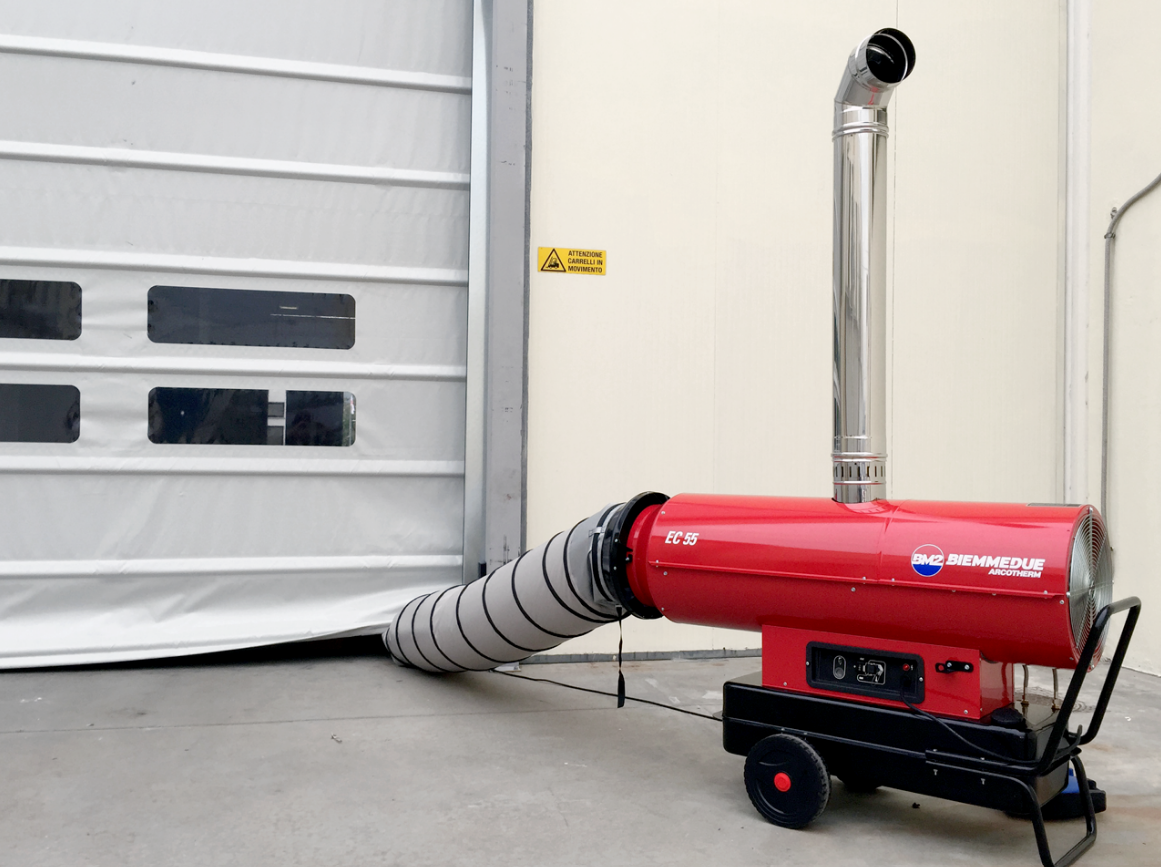 Biemmedue Arcotherm EC55 dieselverwarming met schouw en flexibele warmeluchtslang naast een industriële poort